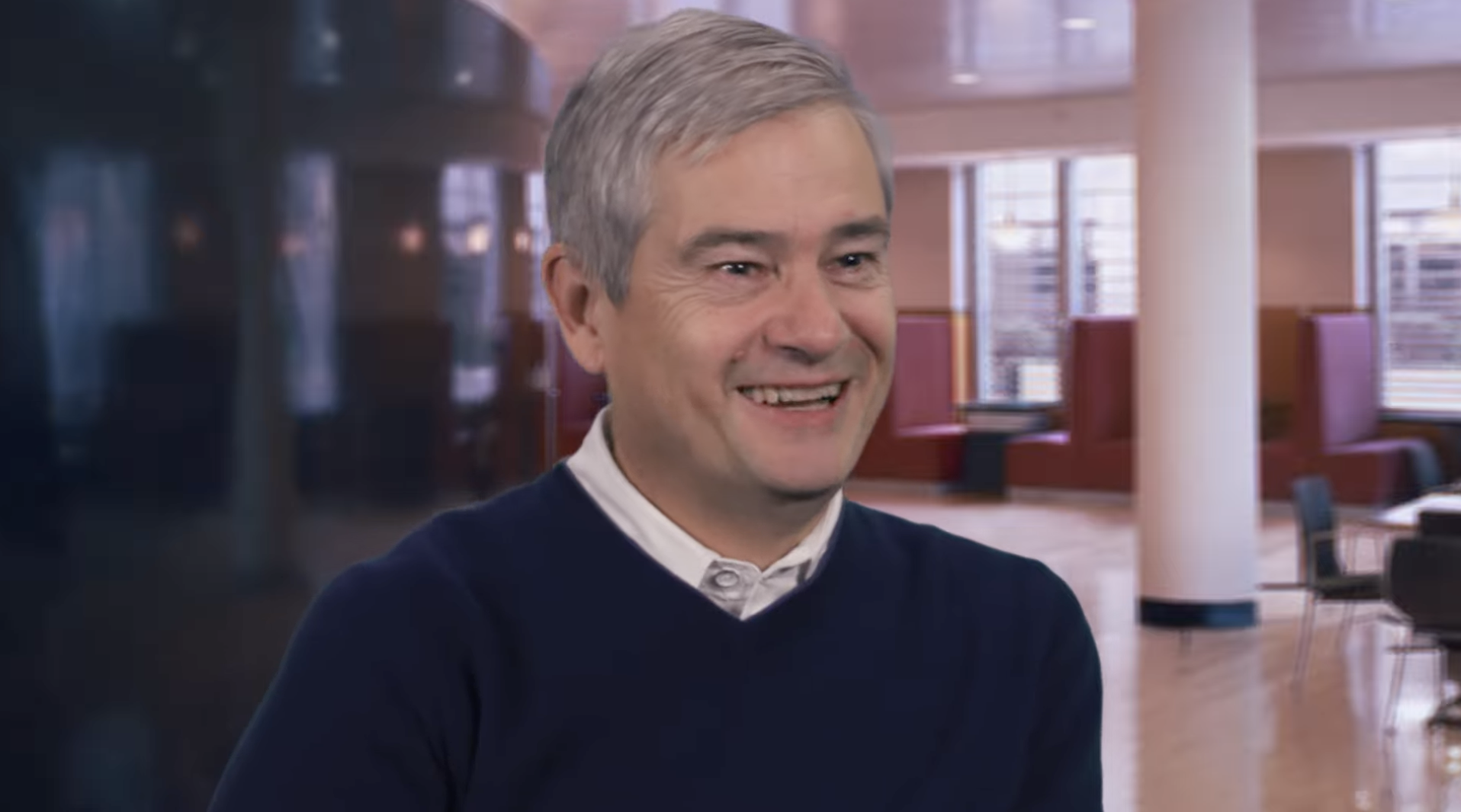 Professor Steve Ansolabehere smiles wearing a collared shirt and sweater