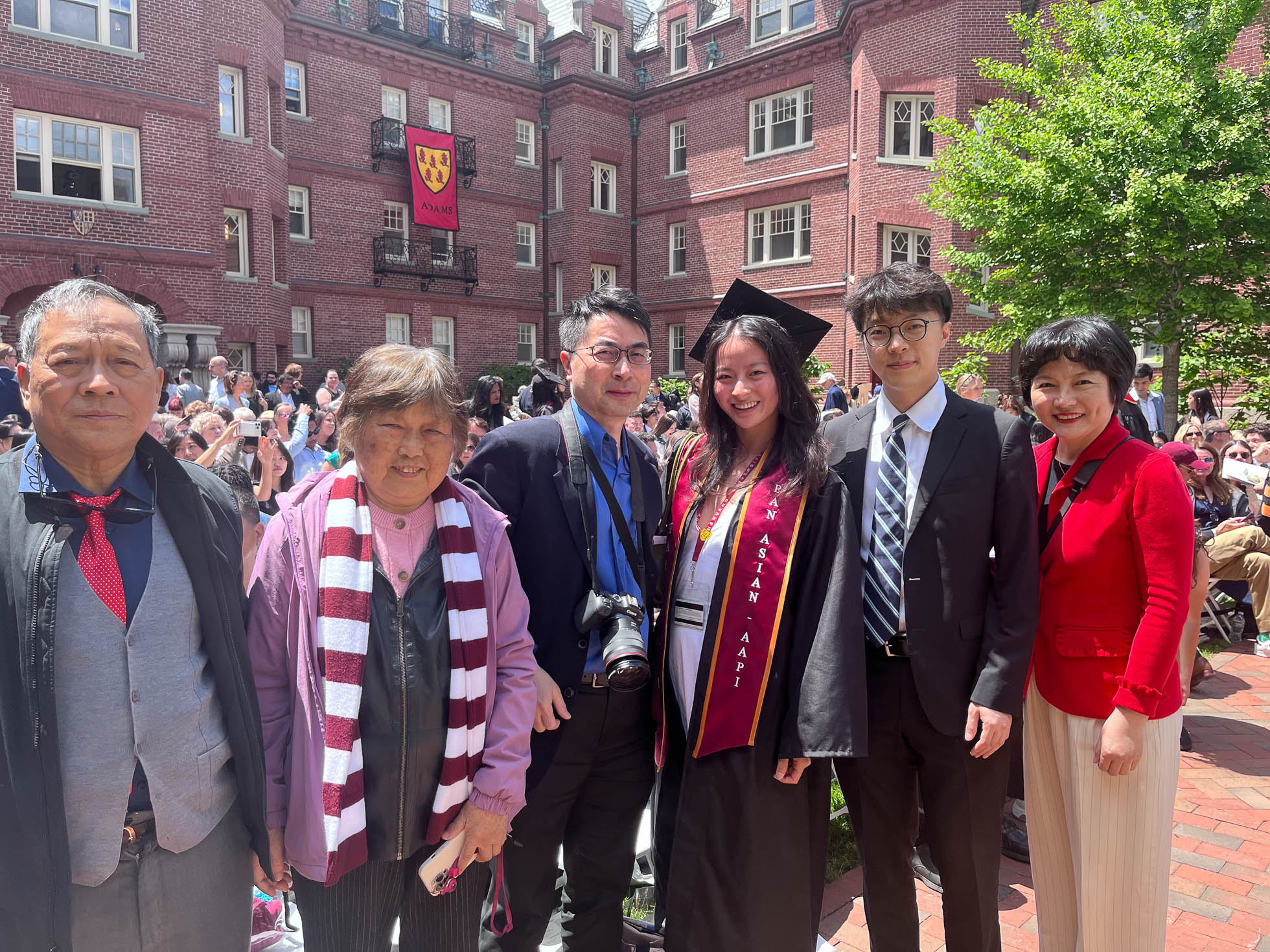 Harvard College graduate Maggie Peng posing for photos at the Adams House diploma ceremony with her parents, brother, and grandparents