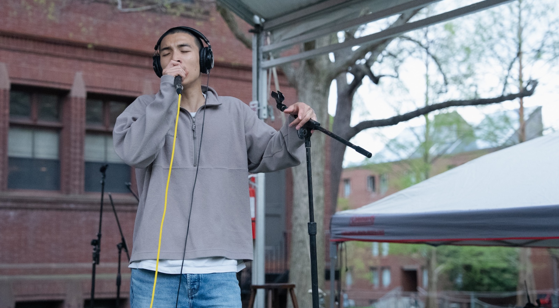 Harvard College student Dexter Suhn closes his eyes and sings on a stage near the University's Sever Quad.
