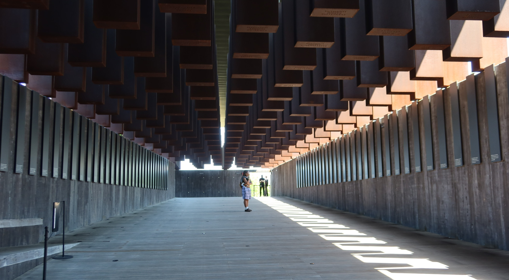 Harvard College student Uzochi Orji pauses to read names inscribed at the National Memorial to Peace and Justice in Montgomery, Ala.