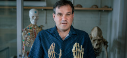 Professor Terence Capellini holding skeletal foot of a hand and foot