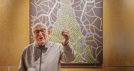 David Bakalar stands before one of his Albert Einstein-inspired “Brain Series” paintings, newly installed on the Harvard University campus at Zimmer Hall.