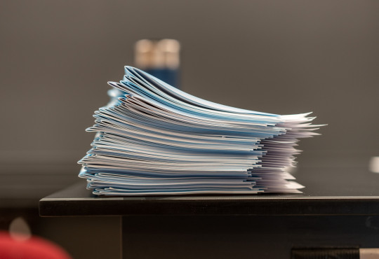 A stack of test blue books. Photo credit David Degner