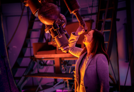 Lisa Kewley, director of the Harvard-Smithsonian Center for Astrophysics and lead author of a new study, peers into the refractor telescope.