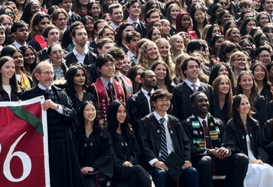A group photo of the Harvard College graduating class in academic regalia