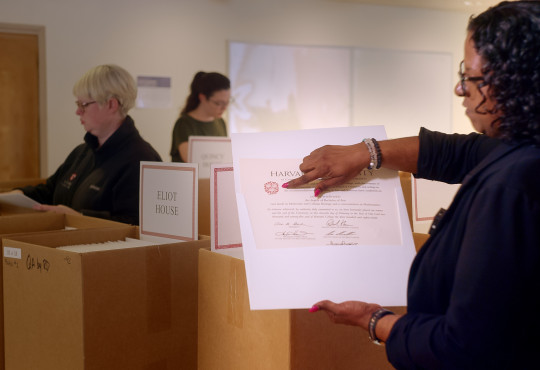 Rae Dragu, Associate Registrar for the Faculty of Arts and Sciences, inspects a Harvard diploma