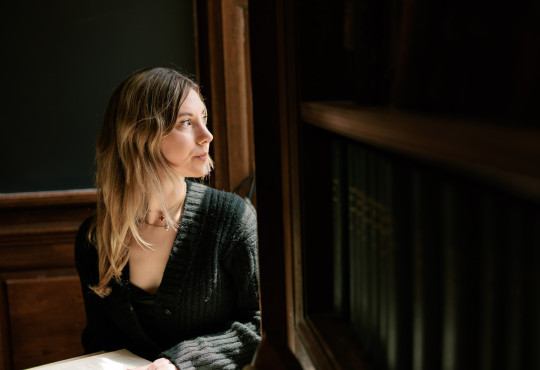 Harvard College student Mary Cipperman gazes out a window on campus