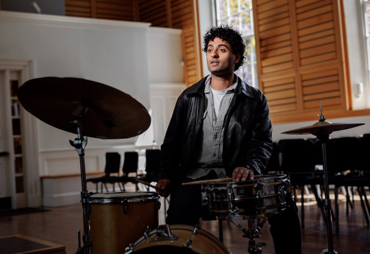 Harvard College senior Raghav Mehrotra, a joint economics and music concentrator, with his drum kit at Holden Chapel.