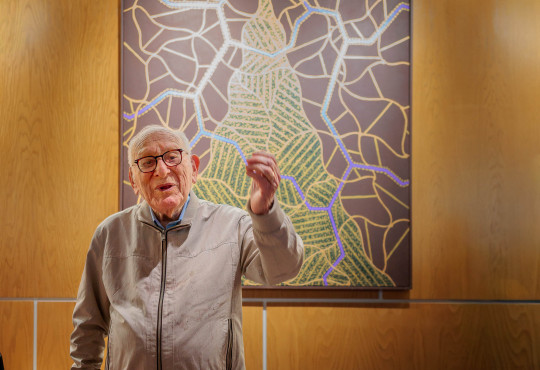 David Bakalar stands before one of his Albert Einstein-inspired “Brain Series” paintings, newly installed on the Harvard University campus at Zimmer Hall.