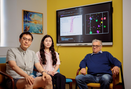 Graduate students Dianzhuo Wang and Jio Jeong with Professor Eugene Shakhnovich seated in front of a TV monitor