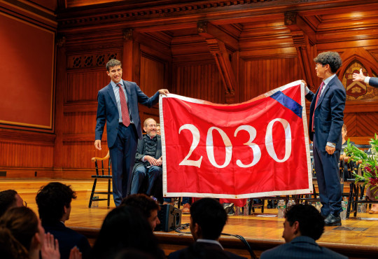 Juniors Zach Berg and Daniel Zhao, co-presidents of the Harvard Undergraduate Association, unfurling a banner welcoming the Class of 2030 at the September 1 Convocation ceremony