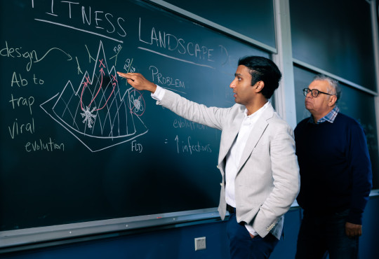 M.D./Ph.D. student Vaibhav Mohanty, at left, with Eugene Shakhnovich, Roy G. Gordon Professor of Chemistry, used a chalkboard to illustrate their fitness landscape design (FLD).