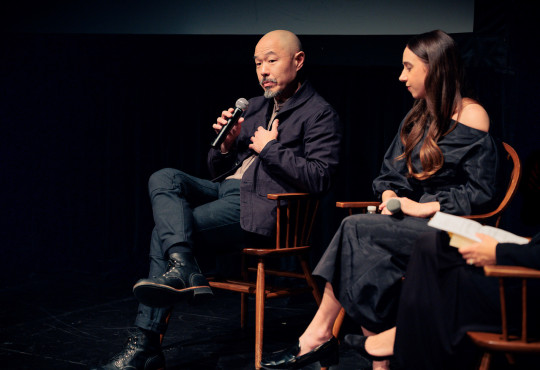 Hoon Lee ’94 speaking on stage about Asian American representation during a discussion at Harvard