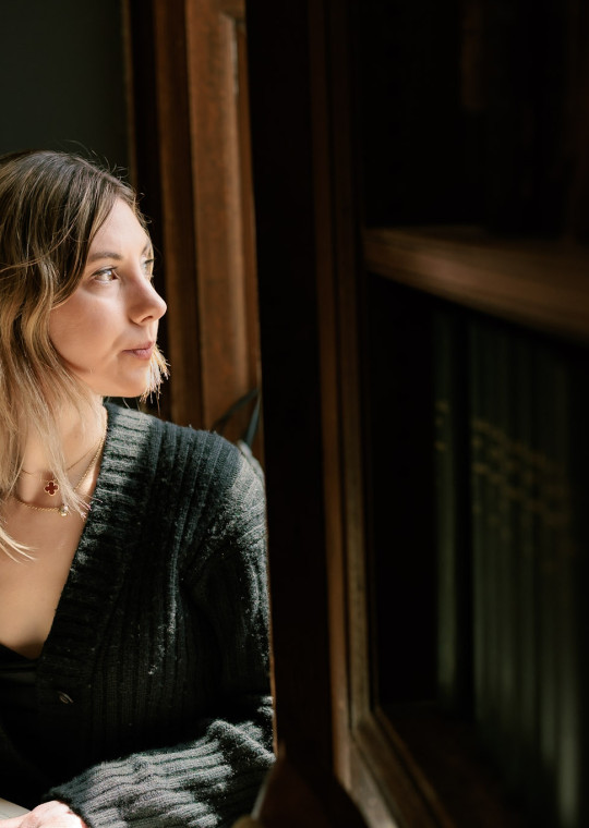 Harvard College student Mary Cipperman gazes out a window on campus