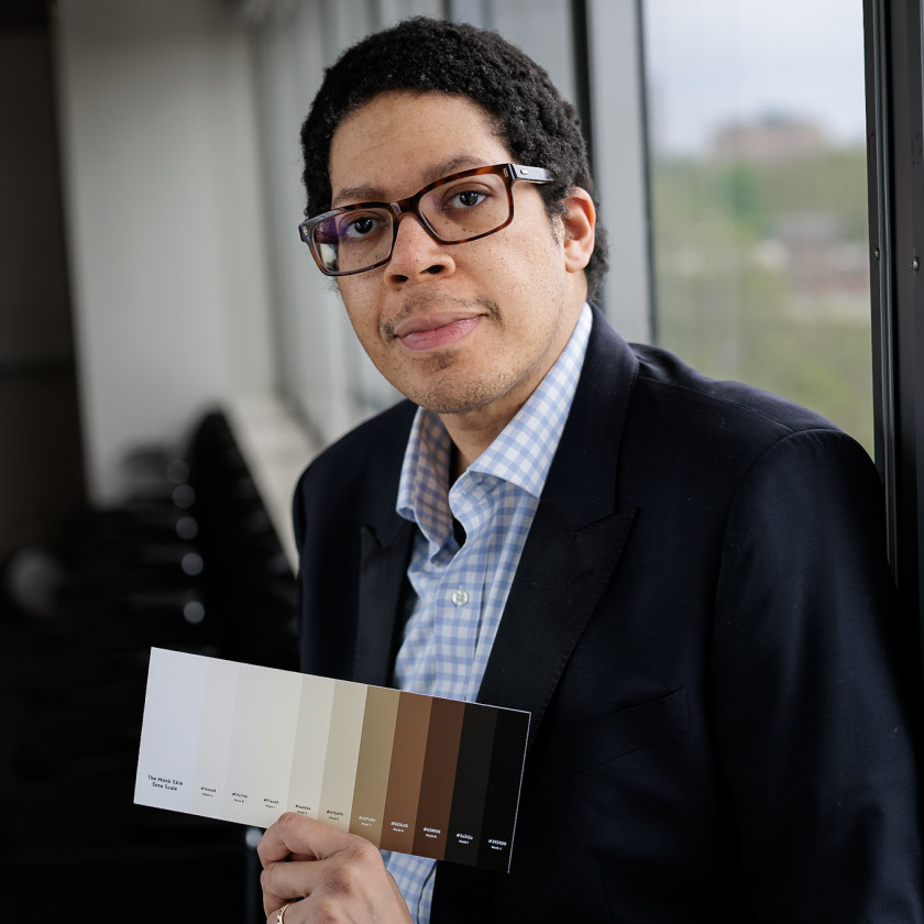Ellis Monk, Professor of Sociology, shows off the 10-point scale he developed to capture a wide variety of skin tones