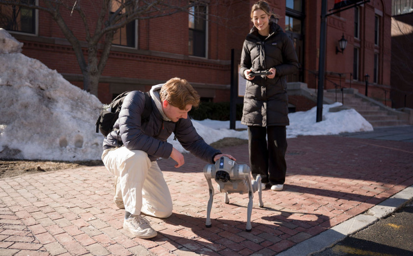 Student Darwin Torrence pets the Go2 Edu like it's a dog and Anna Grace Keller