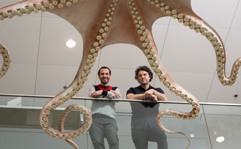 Pablo Villar and Nicholas Bellono under a giant papier mâché octopus sculpture