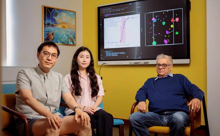 Graduate students Dianzhuo Wang and Jio Jeong with Professor Eugene Shakhnovich seated in front of a TV monitor
