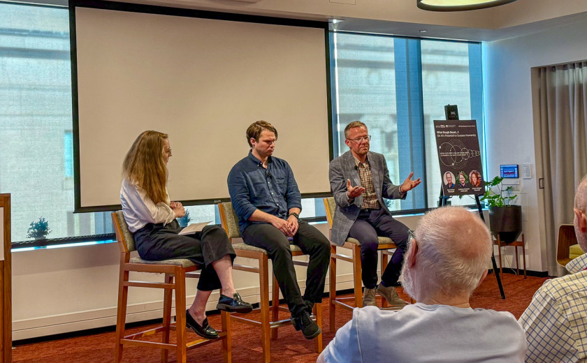 The moderator and two panelists sitting on chairs