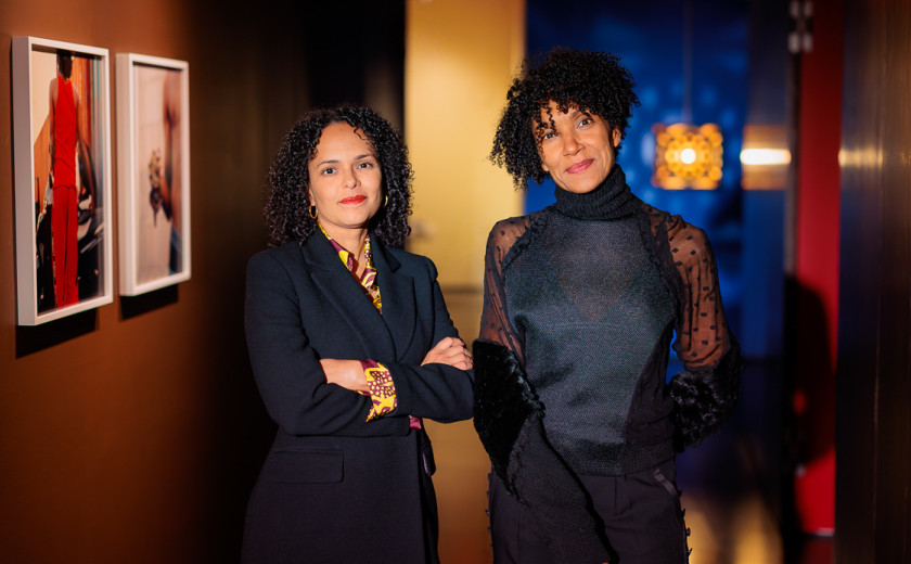 Gallery director Cécile Fromont and curator Claire Tancons posing in front of contemporary Caribbean artworks
