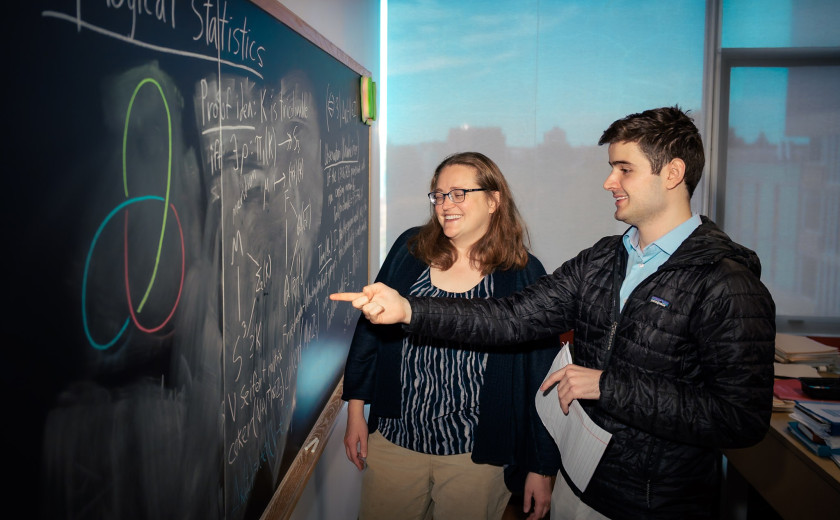 Graduate math student Harvard Ph.D. math student Jack Miller at a chalkboard presenting his work to professor Melanie Matchett Wood