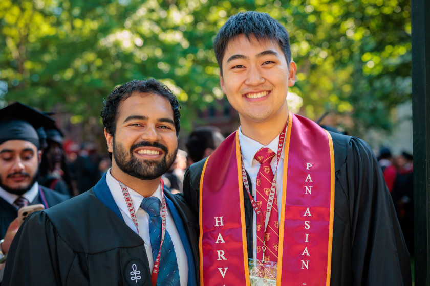 Fraz Javed ’26 and Aidan Chen ’26, dressed in their graduation gowns, in Tercentary Theatre before Commencement
