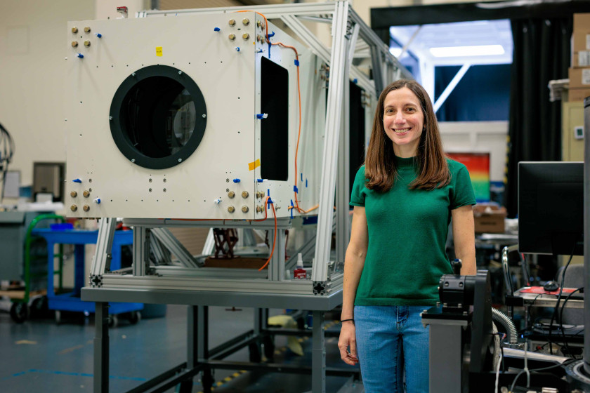 Harvard-Smithsonian Astrophysicist Jenna Samra with the CORSAIR device she designed to study solar eclipses. The photo was taken in July at the Center for Astrophysics' labs in Cambridge, Massachusetts.