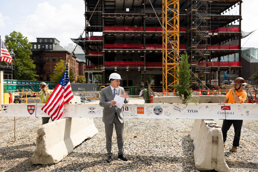 Professor Edward Glaeser wears a hard hat and speaks at a construction site