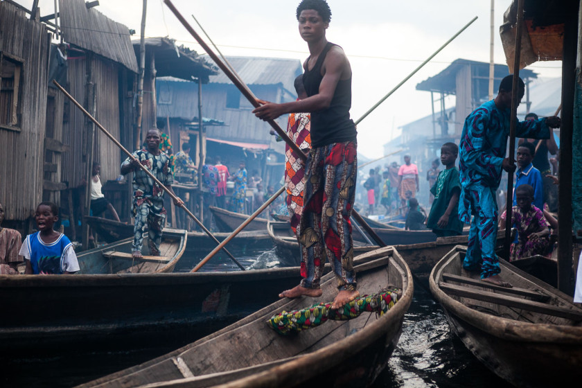 Men stand on fishing boats in Makoko, an informal settlement on the Lagos Lagoon